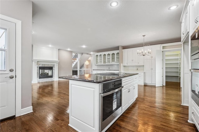 4749 SW Gull Point Dr, Lees Summit, MO 64082 - kitchen with oven, a chandelier, dark wood-type flooring, white cabinets, and recessed lighting