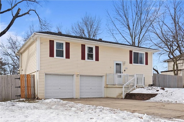 bi-level home with an attached garage and fence