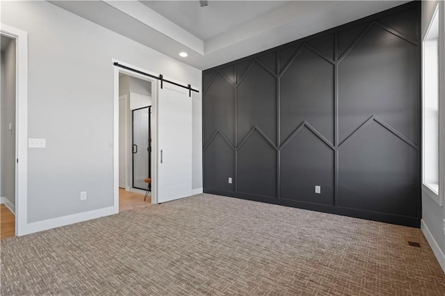 unfurnished bedroom with a barn door