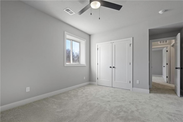 unfurnished bedroom with a closet, ceiling fan, and light carpet