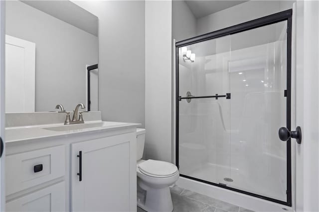 bathroom featuring toilet, a shower with door, and vanity