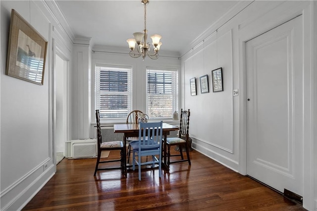 dining area with dark hardwood / wood-style flooring, a notable chandelier, and crown molding