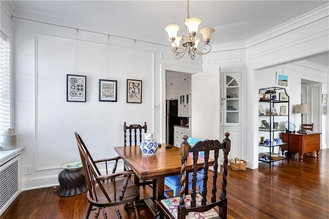 dining room with an inviting chandelier, dark wood-type flooring, and ornamental molding