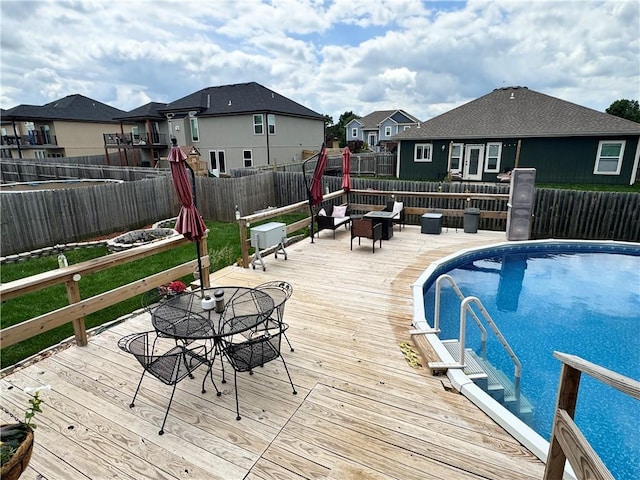 304 S Jackson St, Archie, MO 64725 - view of pool featuring a deck, a residential view, outdoor dining area, and a fenced backyard