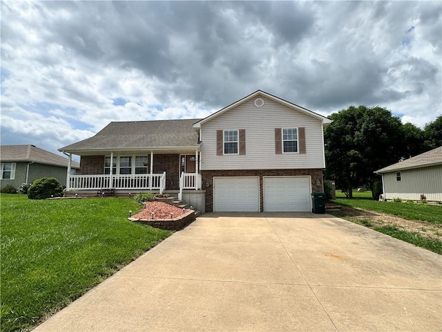 304 S Jackson St, Archie, MO 64725 - split level home featuring brick siding, covered porch, an attached garage, driveway, and a front lawn