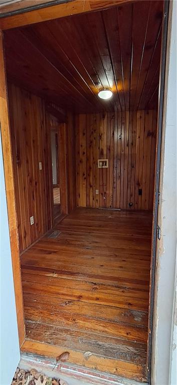 interior space with wooden ceiling, wood-type flooring, and wooden walls