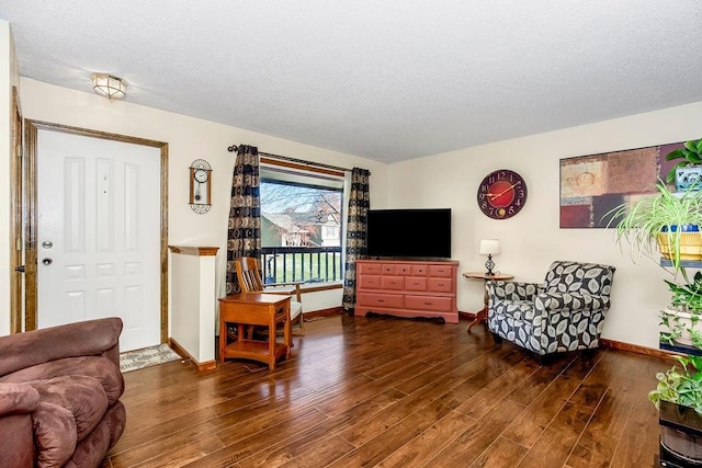 living room featuring a textured ceiling and dark wood finished floors