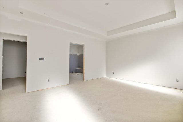 unfurnished bedroom featuring a tray ceiling and a spacious closet