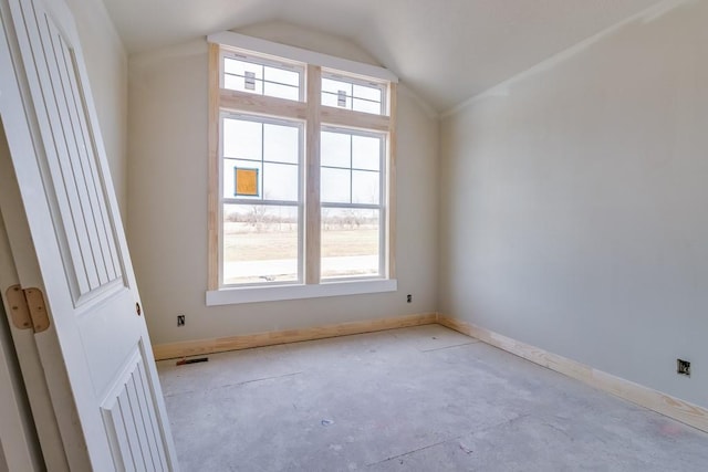 spare room with lofted ceiling, baseboards, and a wealth of natural light