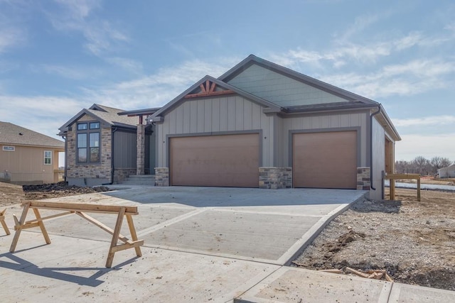 craftsman inspired home featuring a garage, driveway, board and batten siding, and stone siding