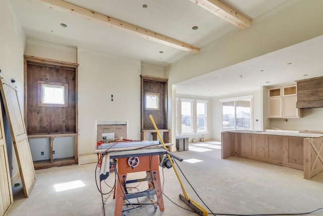 kitchen featuring beam ceiling, a healthy amount of sunlight, and a kitchen island