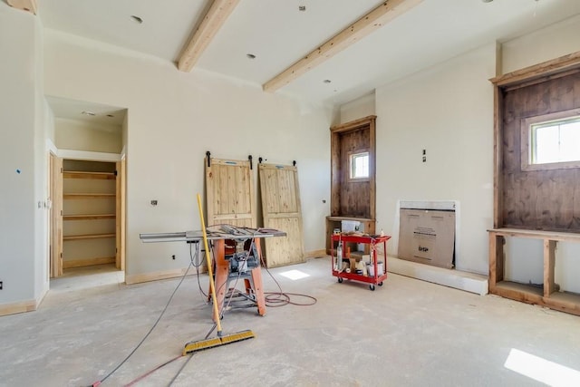 interior space with beamed ceiling and baseboards