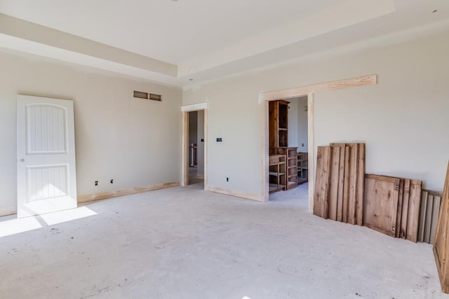 spare room with a raised ceiling and baseboards