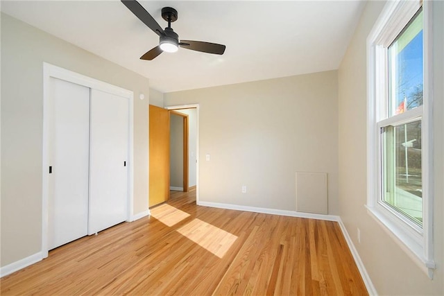 unfurnished bedroom featuring ceiling fan, light wood-type flooring, and a closet