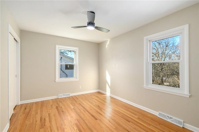 unfurnished bedroom featuring ceiling fan, light hardwood / wood-style floors, and a closet