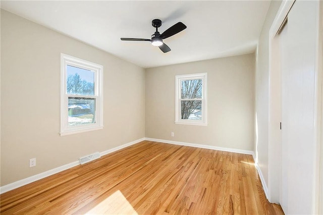 spare room with ceiling fan, plenty of natural light, and light hardwood / wood-style flooring