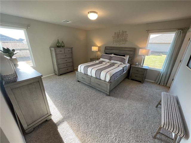 bedroom with multiple windows and light colored carpet