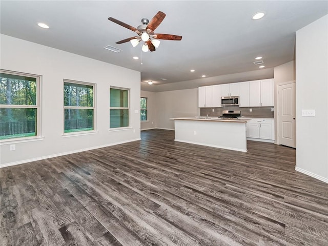 unfurnished living room with ceiling fan and dark hardwood / wood-style floors