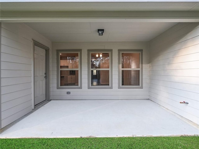 view of exterior entry with a patio area