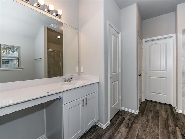 bathroom featuring hardwood / wood-style floors, a shower, and vanity