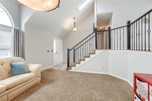 carpeted living room with vaulted ceiling with skylight