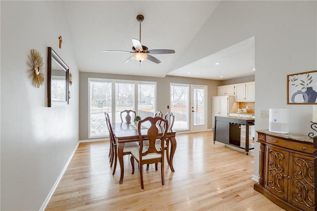 dining room featuring vaulted ceiling, ceiling fan, and light wood-type flooring