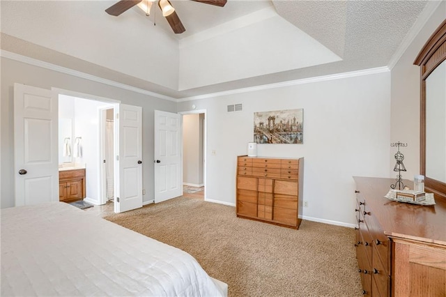 bedroom featuring connected bathroom, ornamental molding, light colored carpet, ceiling fan, and a raised ceiling