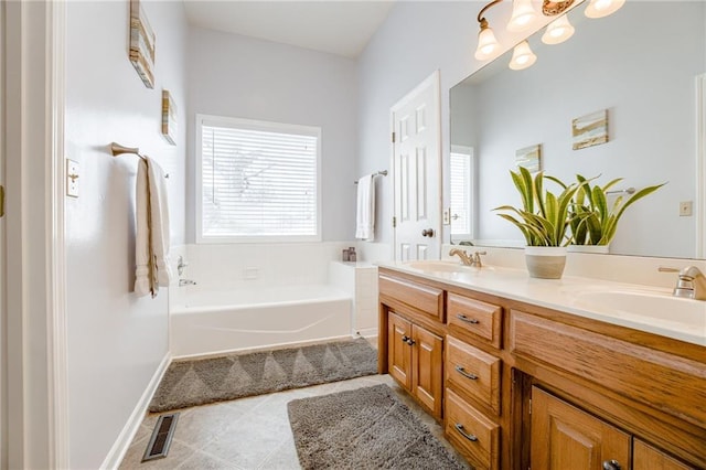 bathroom featuring vanity, plenty of natural light, a washtub, and tile patterned floors