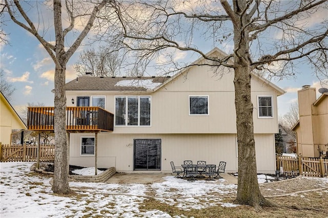 snow covered back of property with a balcony