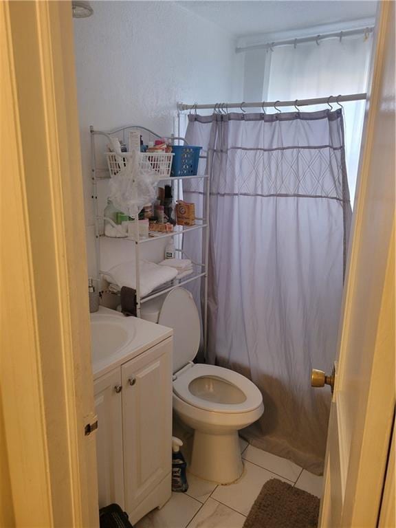 full bathroom featuring vanity, shower / tub combo, tile patterned floors, and toilet