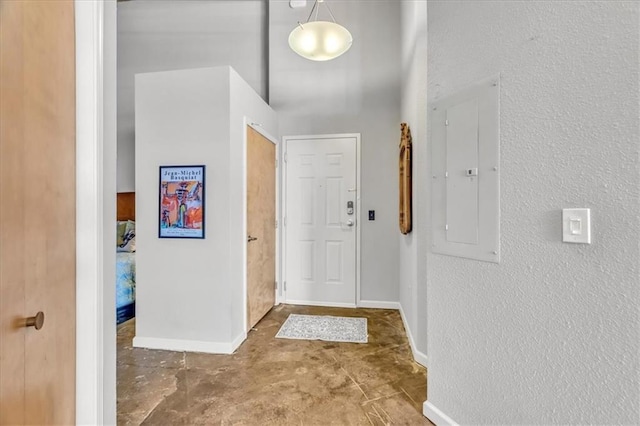 interior space featuring concrete floors, electric panel, and baseboards