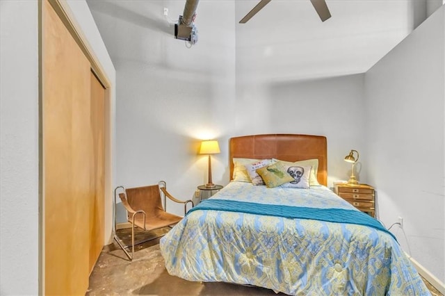 bedroom featuring a ceiling fan, a closet, and unfinished concrete flooring