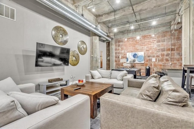 living area with brick wall and visible vents