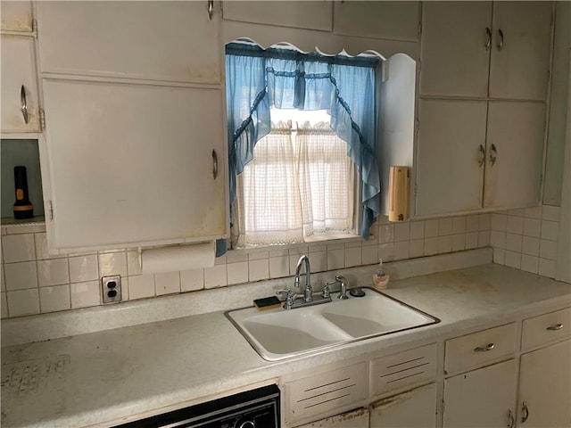 kitchen with tasteful backsplash, sink, and white cabinets