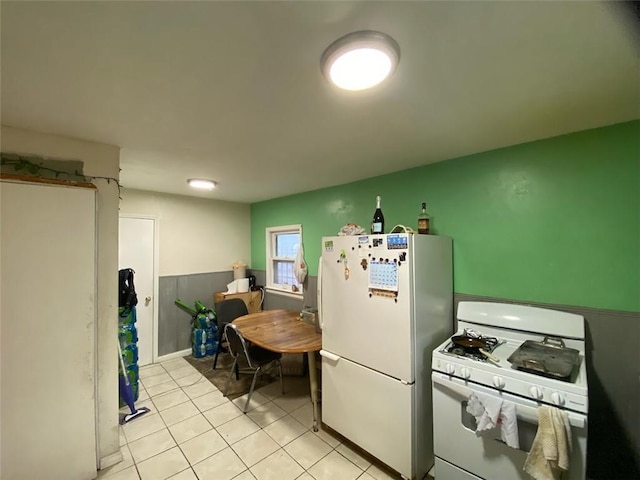 kitchen featuring light tile patterned floors and white appliances