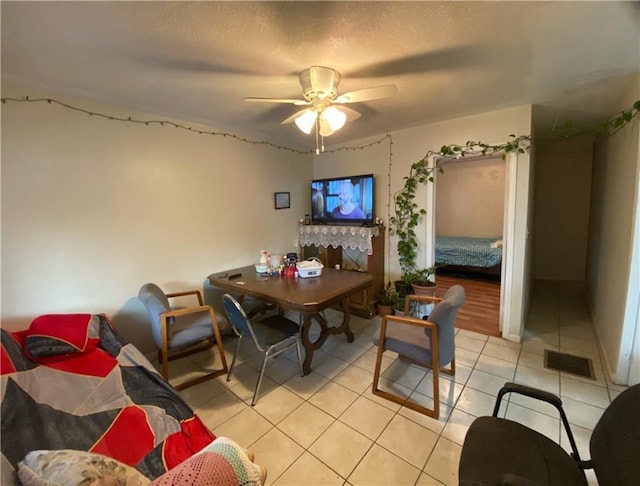 dining room featuring light tile patterned flooring, ceiling fan, and a textured ceiling