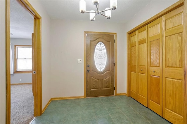 carpeted entryway featuring a notable chandelier