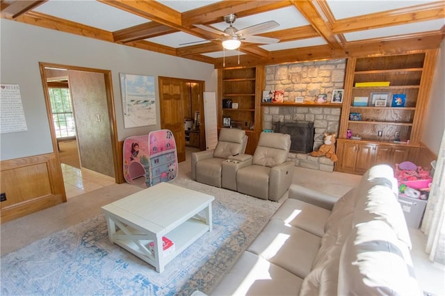 living room with beam ceiling, built in shelves, a fireplace, wood walls, and coffered ceiling