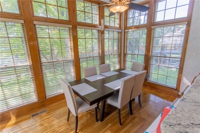 dining space featuring wood-type flooring and ceiling fan