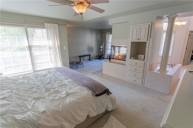 carpeted bedroom featuring decorative columns and ceiling fan