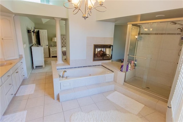 bathroom featuring decorative columns, shower with separate bathtub, vanity, and tile patterned flooring