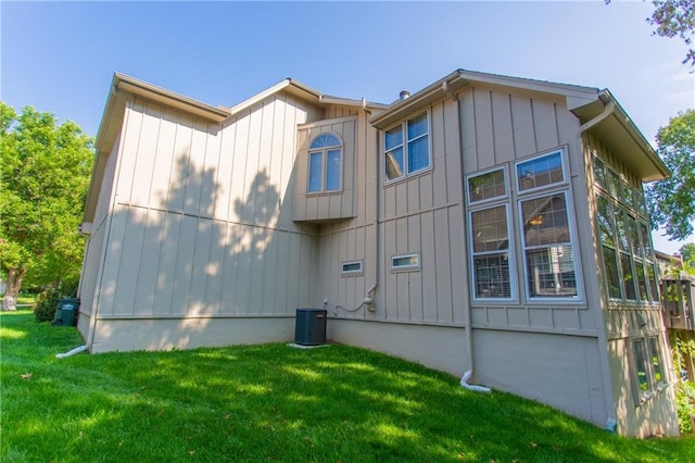 view of property exterior featuring a lawn and central AC