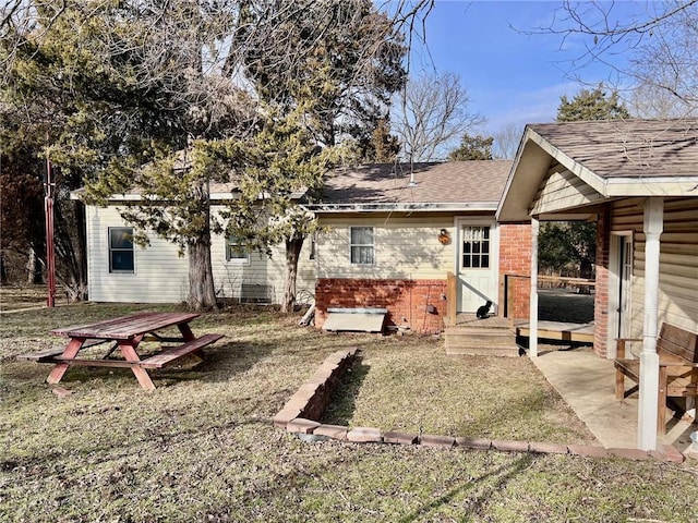 rear view of property featuring a yard