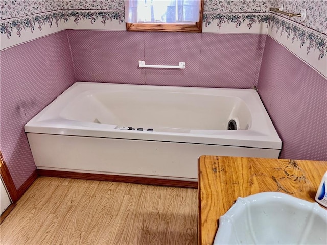 bathroom with sink, hardwood / wood-style flooring, and a bathing tub