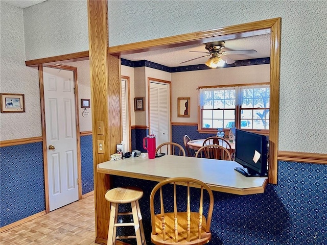 dining space with ceiling fan and light parquet flooring