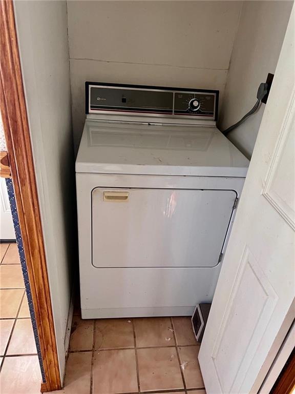 laundry room with light tile patterned floors and washer / dryer