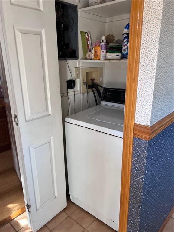 laundry area featuring light tile patterned flooring and washer / dryer