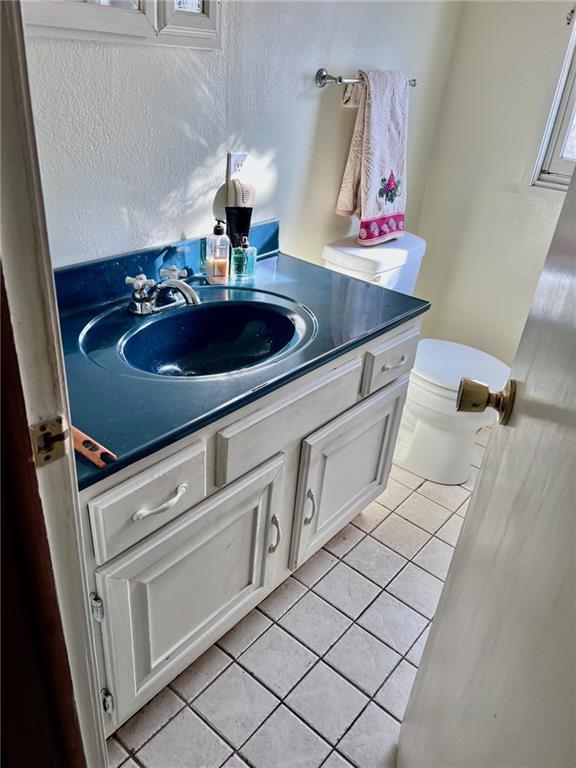 bathroom featuring toilet, vanity, and tile patterned flooring