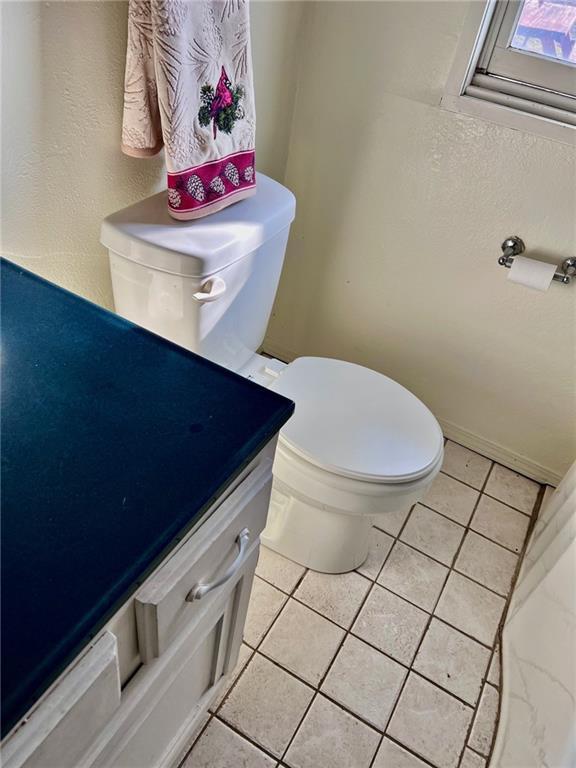 bathroom featuring toilet, tile patterned floors, and vanity