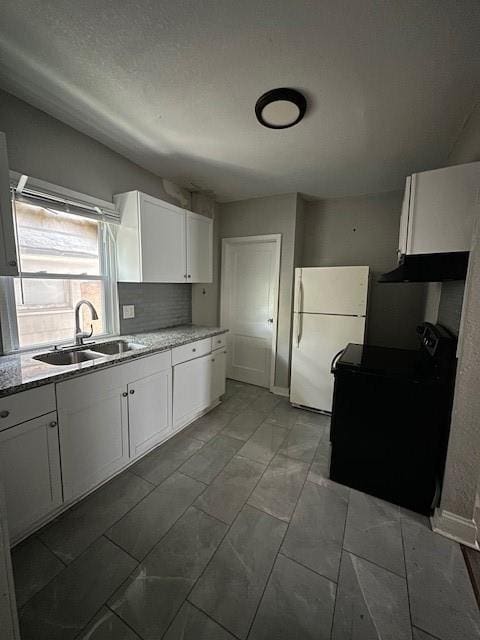 3920 S Benton Ave, Kansas City, MO 64130 - kitchen with black electric range, a sink, freestanding refrigerator, under cabinet range hood, and white cabinets